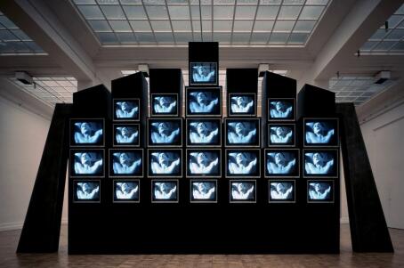 Marie-Jo Lafontaines, Les Larmes d’acier, 1987, Videoinstallation, 27 Monitoren, 420 x 730 x 180 cm, 7’41“ loop