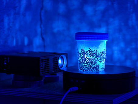 Allen-Golder Carpenter - Free jah morant , 2025 Urine test cups, ash, projector, moving image, gemstones, urine. Spatial installation. Dimensions variable - TICK TACK
